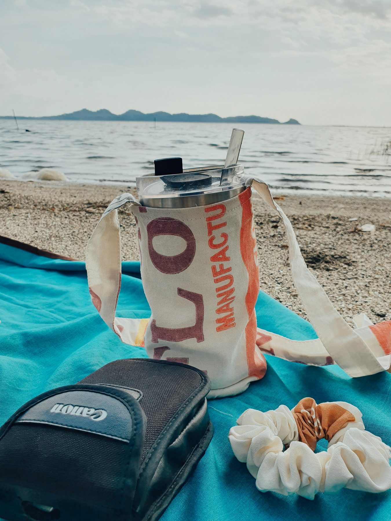 A tumbler holder on a beach blanket