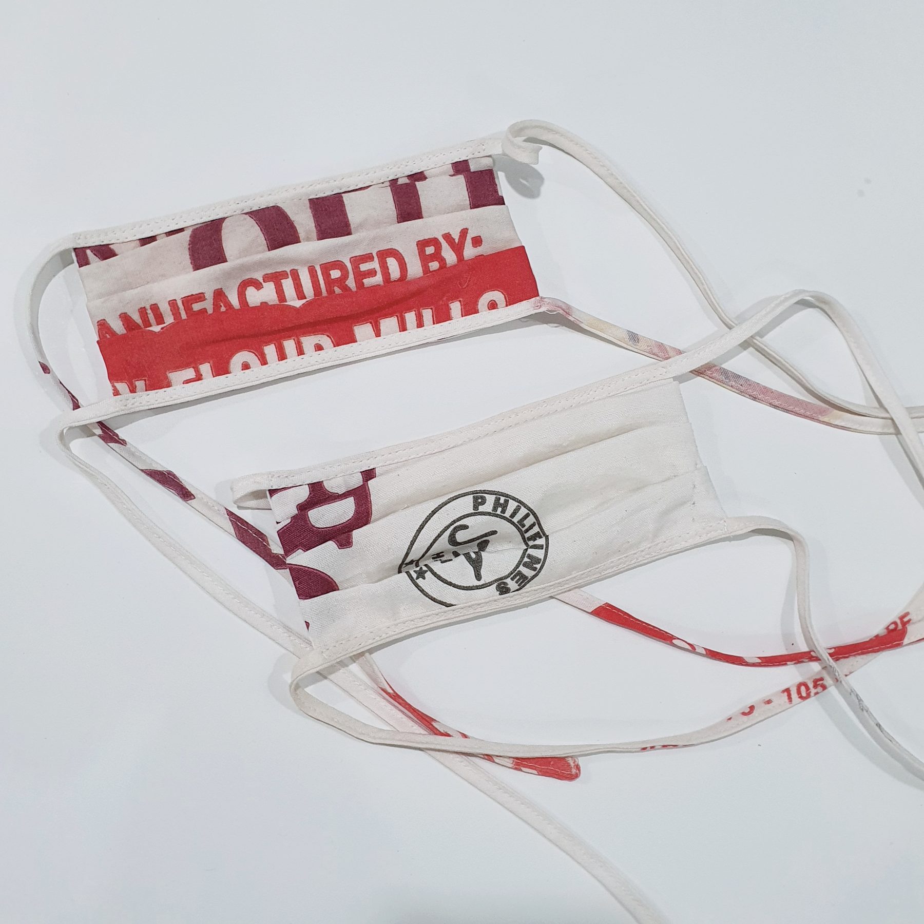 Flour-Print Face Mask: two reusable katsa face masks with ties, showing the original flour-sack print.